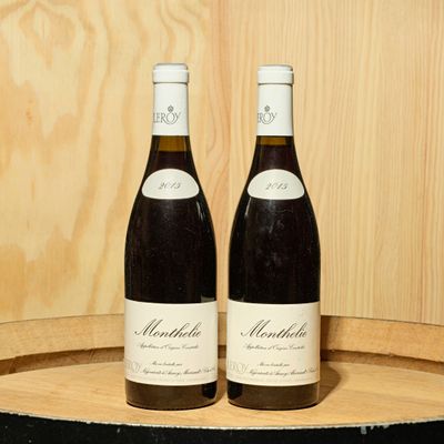 deux bouteilles de vin posées l'une à côté de l'autre sur un tonneau