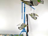 trois oiseaux posés sur un socle