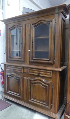 un meuble en bois avec une porte en verre dans une pièce