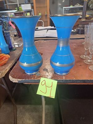 trois vases bleus posés sur une table, avec une étiquette de prix