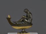 sculpture en bronze représentant une femme assise sur un bateau, tenant un oiseau dans la main