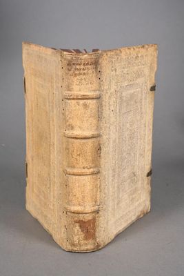 an old book sitting on top of a table next to a gray wall