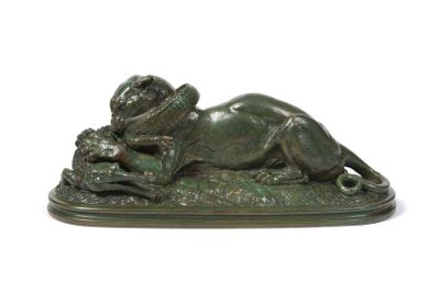 bronze statue of a lion laying on a rock with a snake in its mouth