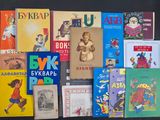 several children ' s books are lined up on a black surface