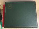 a green book with a red cover sitting on a table