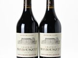 two bottles of red wine sitting next to each other on a white surface