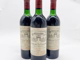 trois bouteilles de vin rouge posées l'une à côté de l'autre sur une surface blanche
