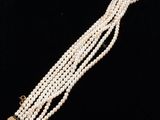 a close up of a necklace with pearls on a black background