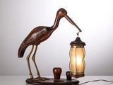 une image représentant une lampe sur laquelle est posé un oiseau