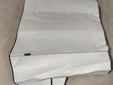 une pile de papier posée par terre à côté d'une pile de livres