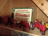 many toy tractors on a shelf in a room