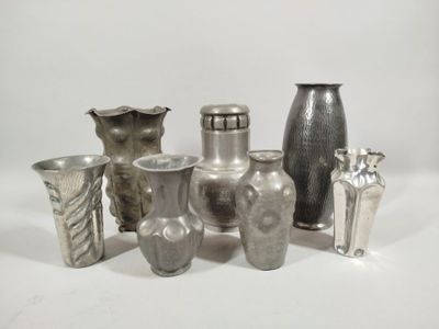 a lot of silver vases sitting on a white surface