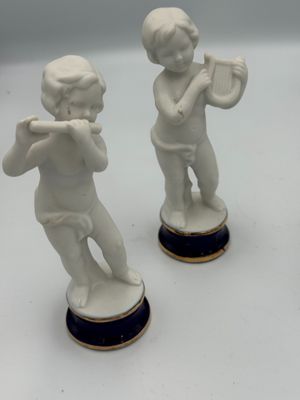 deux figurines représentant un garçon jouant de la trompette et une fille jouant de la flûte