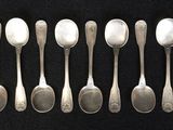 six spoons are lined up in a row on a black surface