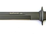 an image of a knife with a black handle on a white surface