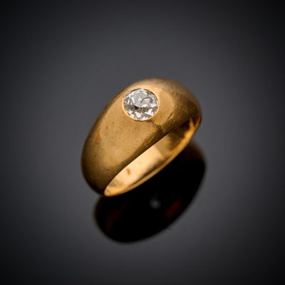 un gros plan d'une bague en or sertie d'un diamant sur un fond noir