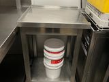 a bucket sitting on a metal table in a kitchen