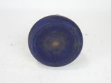 a small blue glass object on a white surface