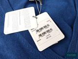 the label on a blue sweater is attached to a hanger