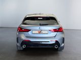 the rear end of a silver car in a white room