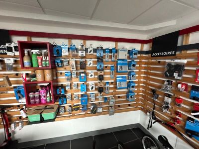 un vélo dans un magasin de vélos où de nombreux articles sont accrochés au mur