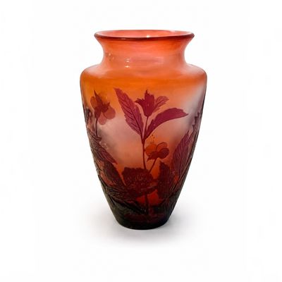 un vase avec un motif floral sur une surface blanche