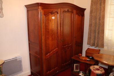 une photo d'un salon avec une grande armoire en bois