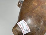 a brown vase with a sticker on it