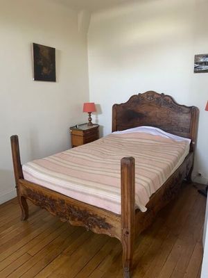 un lit avec un cadre en bois dans une petite chambre