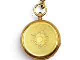 an antique gold pocket watch with a chain on a white background