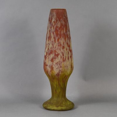 a red and yellow vase sitting on a white table