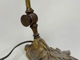 an antique brass table lamp with a bird on it ' s head