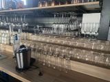 bottles and glasses are lined up on a shelf in a bar