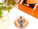 an orange box with a watch on it next to a plant