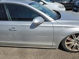 a silver car parked in a parking lot with other cars in the background