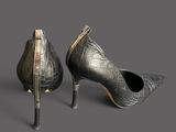 pair of black leather high heeled shoes on a grey background