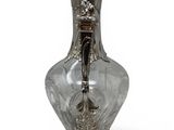 a glass vase with a silver handle on a white background