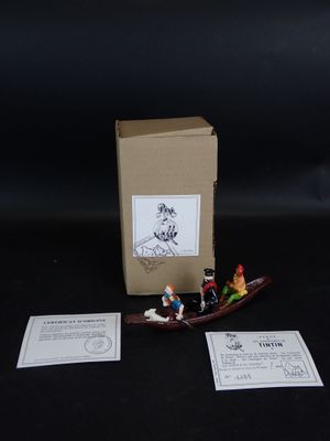 un petit bateau miniature avec des personnages à bord, à côté d'une boîte