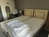 deux lits dans la chambre, recouverts de draps blancs