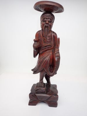 l'image d'une statue en bois représentant un homme avec un chapeau sur la tête