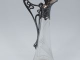 un vase en argent et en verre surmonté d'un oiseau