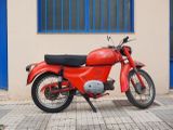 a red motorcycle parked in front of a building