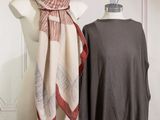 two mannequins with scarves on display in front of a white wall