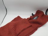 an orange sweater sitting on top of a white table next to a hair dryer