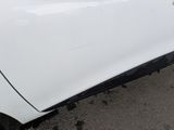 a close up of a white car with a denting on the side