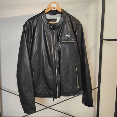 une veste en cuir noir suspendue à un cintre dans un placard