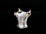 un petit vase contenant des fleurs, posé sur une surface noire