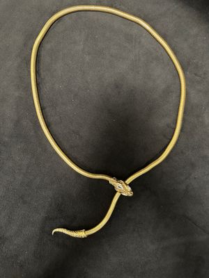 a gold necklace with a snake ' s head on it