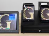 trois téléphones portables posés sur un socle noir