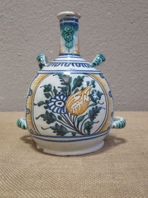 un vase bleu et blanc orné d'une fleur jaune